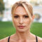 Picture of amazing strong young sports woman standing outdoors. Looking camera.